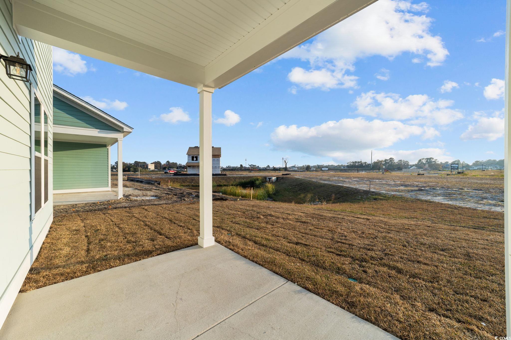 774 Ebb Tide Road Little River, SC 29566 - Photo 8 of 39 View of property exterior with a shingled roof and a yard