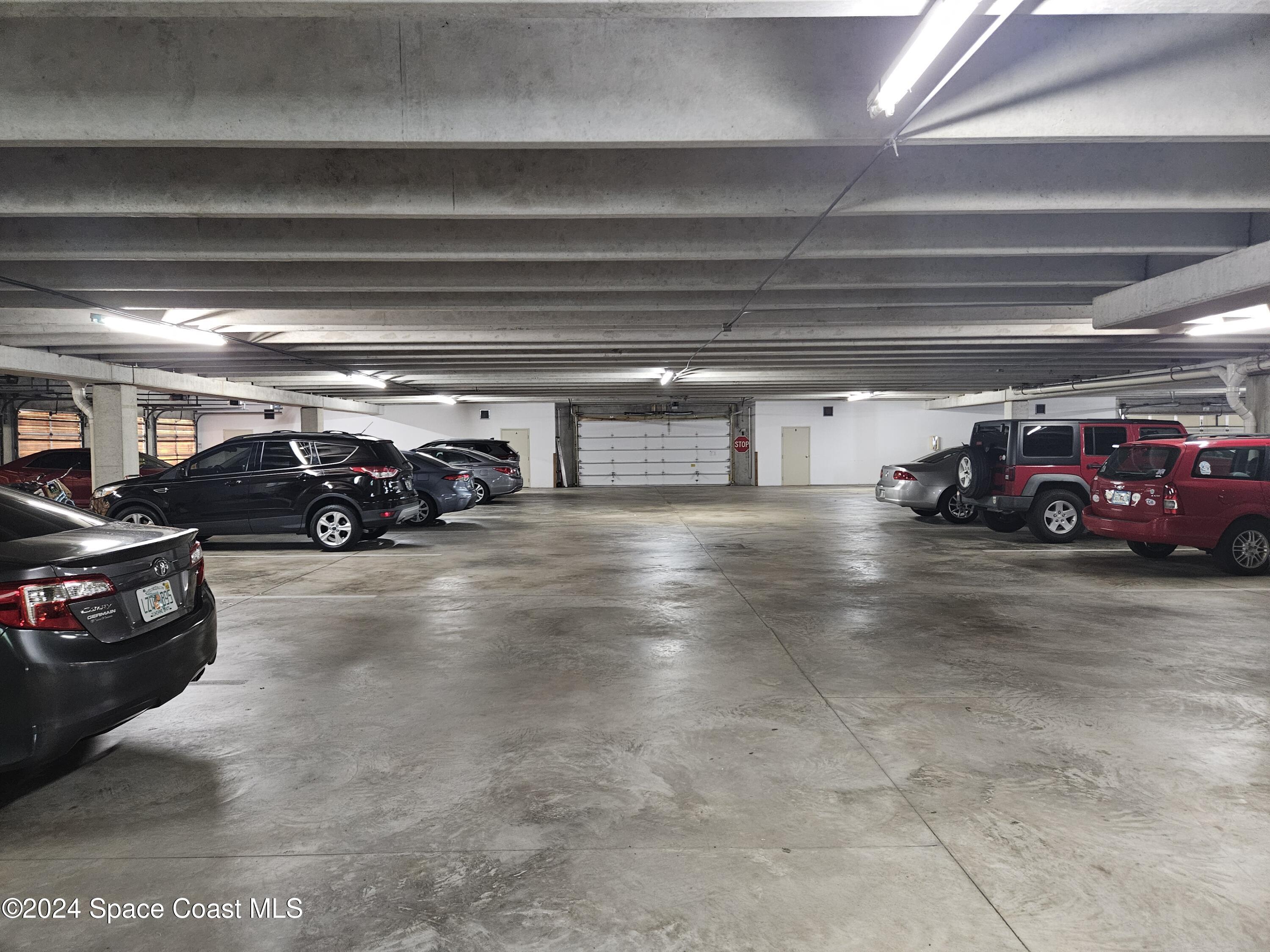 1750 Commodore Boulevard, Unit 2101 Cocoa Beach, FL 32931 - Photo 19 of 21 a view of parking garage with cars