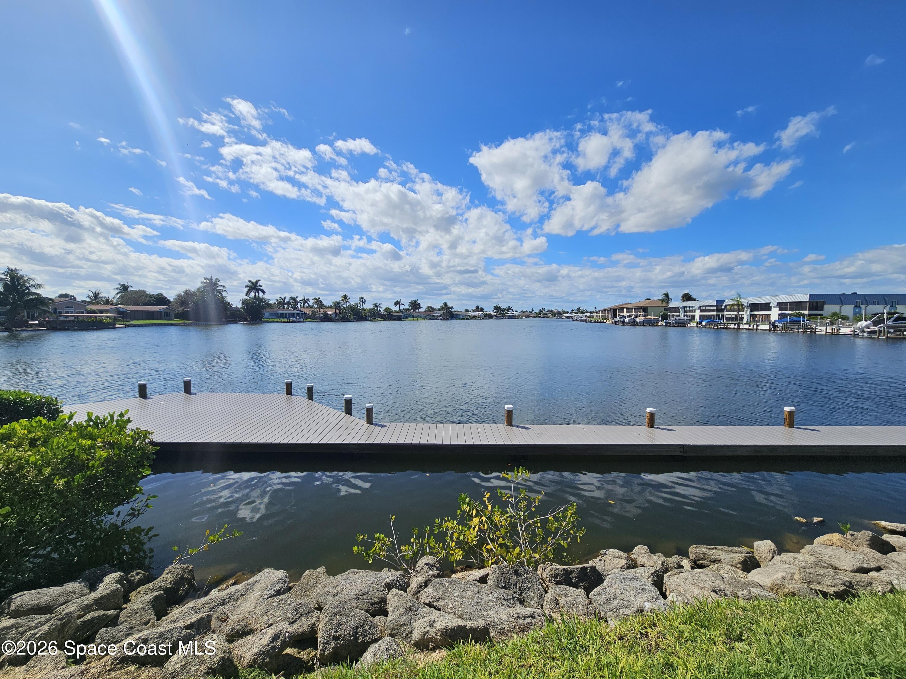 1750 Commodore Boulevard, Unit 2101 Cocoa Beach, FL 32931 - Photo 2 of 21 a view of a lake with lawn chairs