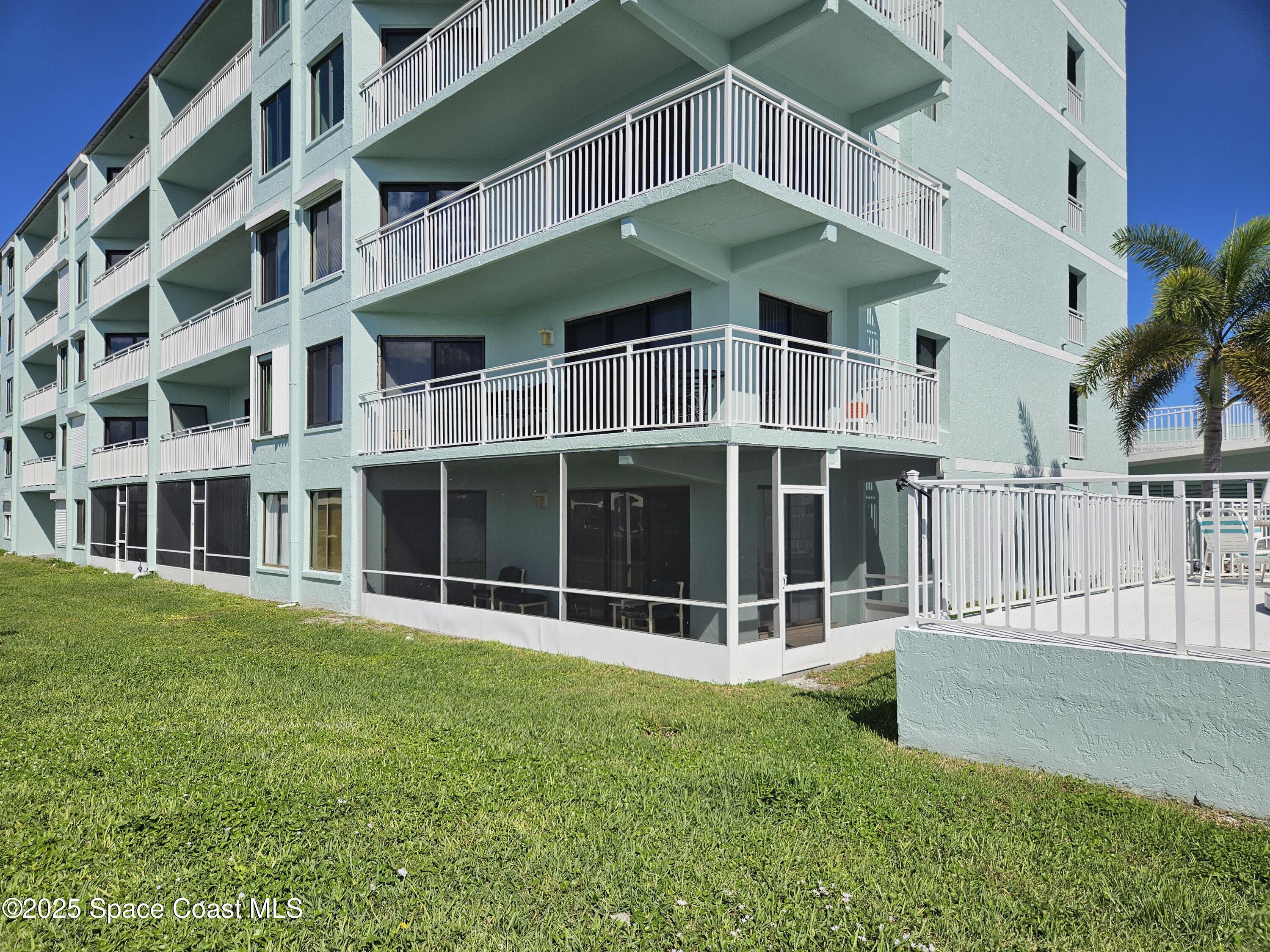 1750 Commodore Boulevard, Unit 2101 Cocoa Beach, FL 32931 - Photo 4 of 21 a large building with a garden