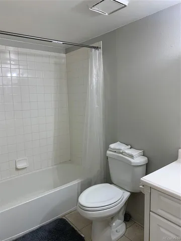 a white toilet sitting next to a bath tub