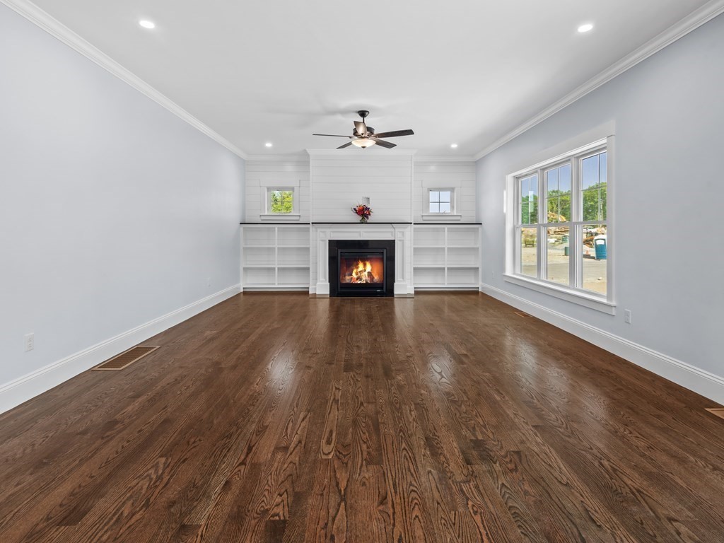 87 Brigham Hill Road Attleboro, MA 02703 - Photo 10 of 42 an empty room with windows fireplace and a ceiling fan