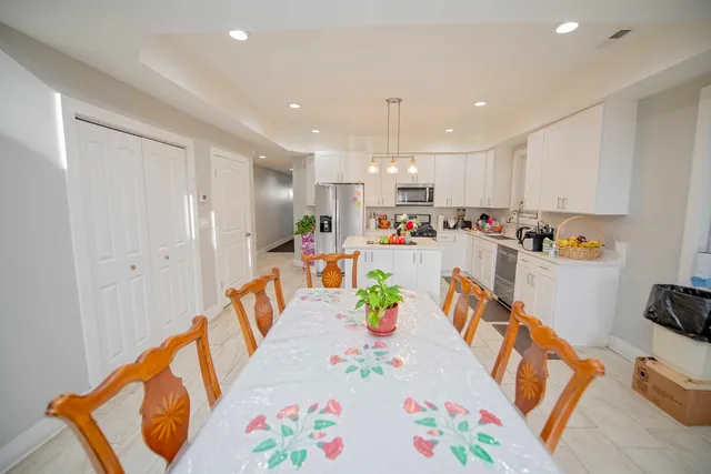 a view of kitchen with stainless steel appliances furniture refrigerator and wooden floor
