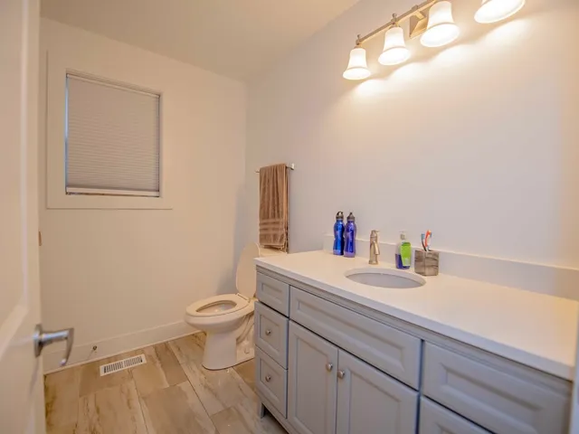 a bathroom with a sink a toilet and a mirror