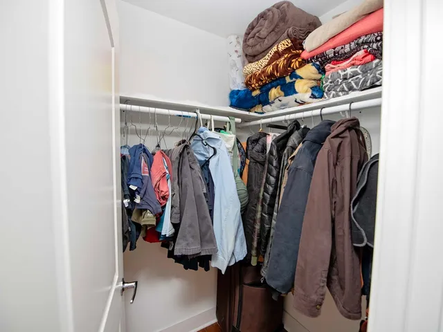 a view of walk in closet with clothes and shoes