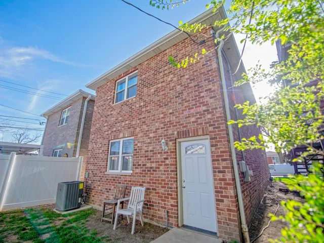 a brick building with a tree in front