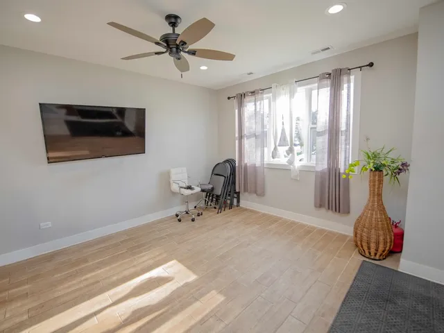 a view of a livingroom with a chandelier fan and a window