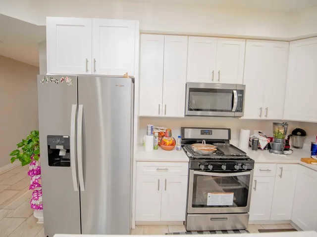 a kitchen with stainless steel appliances a stove a refrigerator and a cabinets