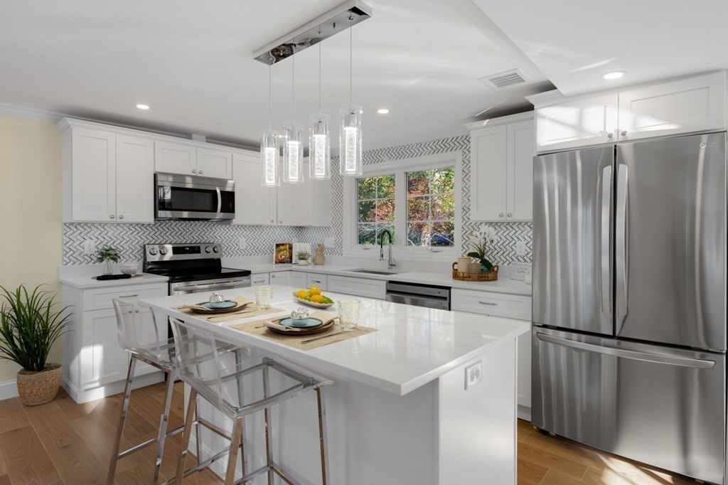 15 Red Acre Road Stow, MA 01775 - Photo 12 of 42 a kitchen with a sink a refrigerator and chairs