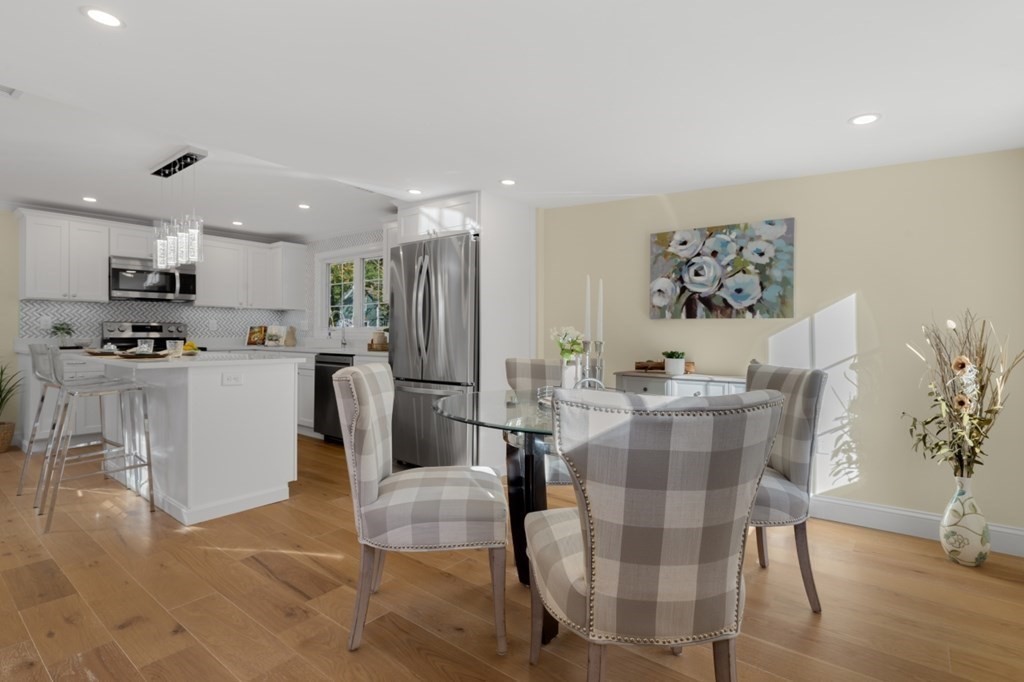 15 Red Acre Road Stow, MA 01775 - Photo 16 of 42 a kitchen with stainless steel appliances kitchen island granite countertop a refrigerator a stove a microwave oven with a dining table and chairs