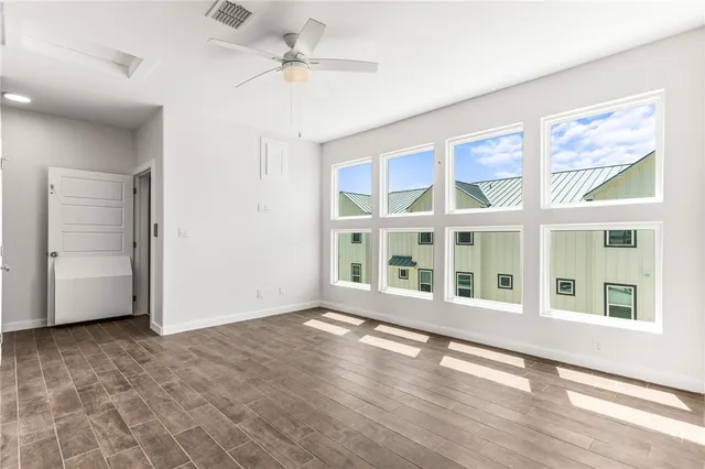 a view of kitchen with kitchen island a sink wooden floor and a refrigerator