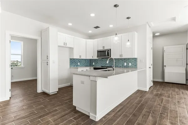 a kitchen with stainless steel appliances granite countertop a stove and a microwave