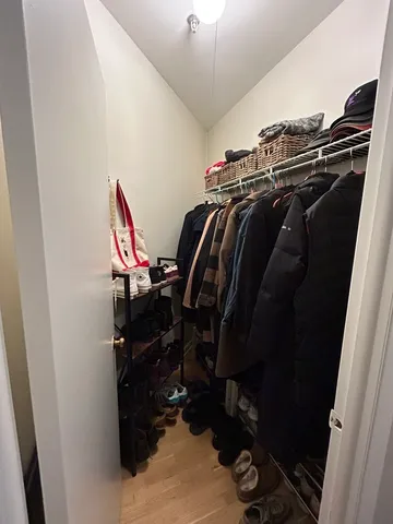 a view of walk in closet with clothes and shoes