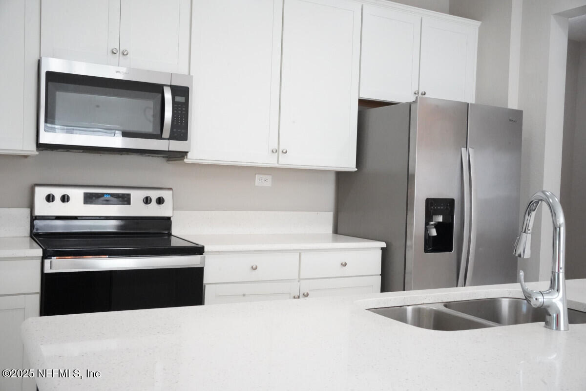 855 Sycamore Way Orange Park, FL 32073 - Photo 11 of 43 a kitchen with stainless steel appliances granite countertop a refrigerator a stove and a sink with wooden floor