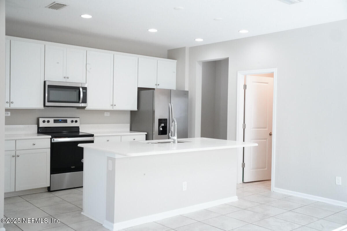 855 Sycamore Way Orange Park, FL 32073 - Photo 10 of 43 a kitchen with stainless steel appliances a refrigerator sink and microwave