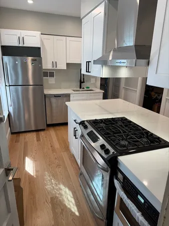 a kitchen with kitchen island a counter top space a sink stainless steel appliances and cabinets