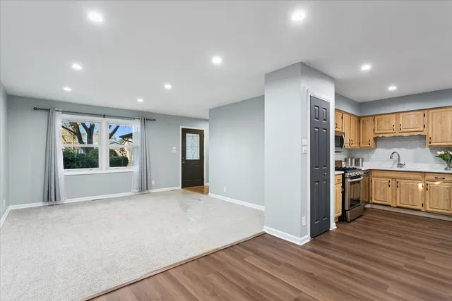 a view of kitchen with stainless steel appliances granite countertop a stove and a refrigerator