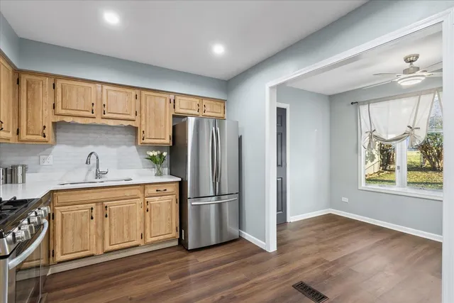 a kitchen with a refrigerator sink and cabinets