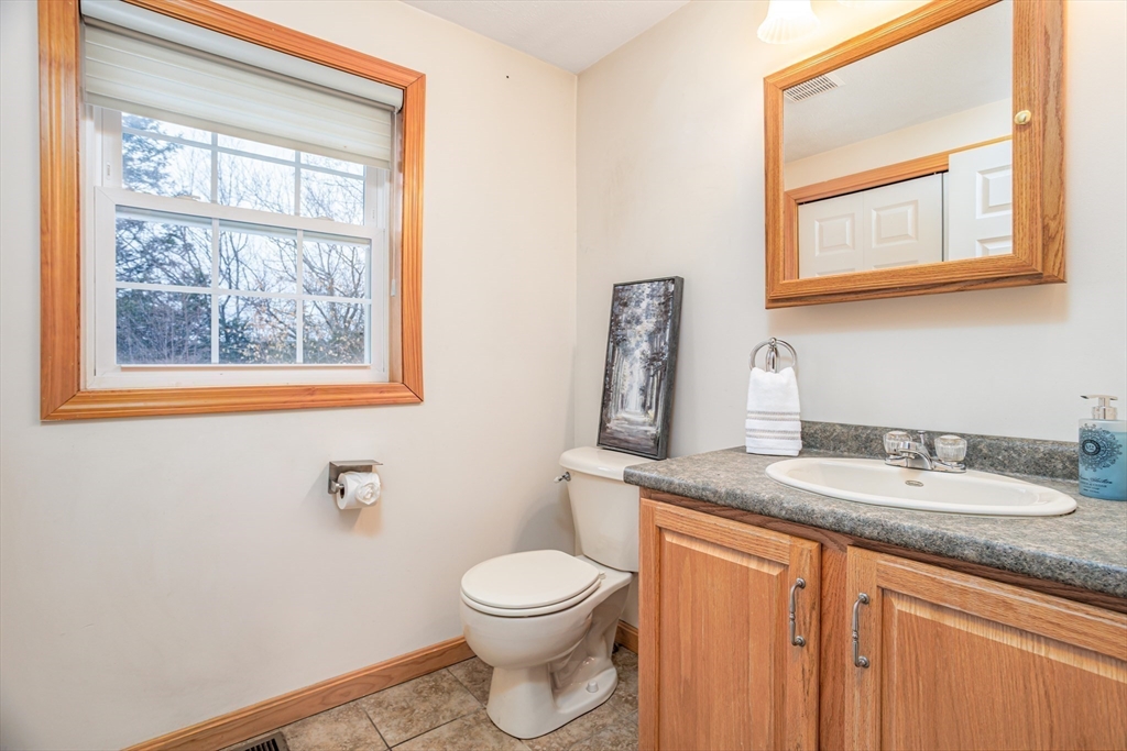 326 Matthews Street Gardner, MA 01440 - Photo 3 of 42 a bathroom with a granite countertop toilet a sink and a window