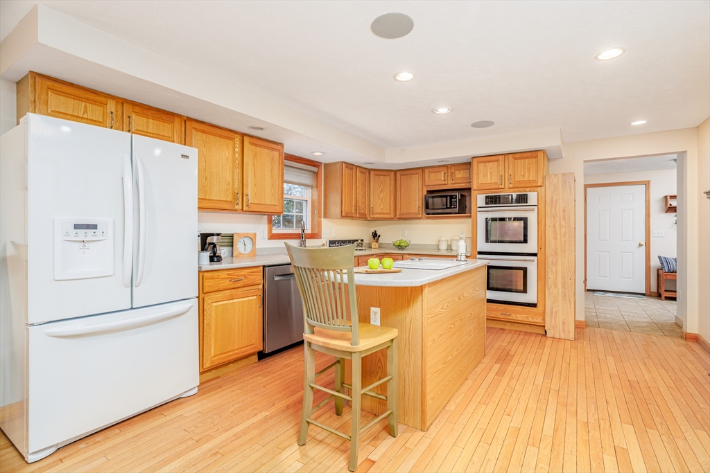 326 Matthews Street Gardner, MA 01440 - Photo 4 of 42 a kitchen with a refrigerator a stove top oven and a center island with wooden floor