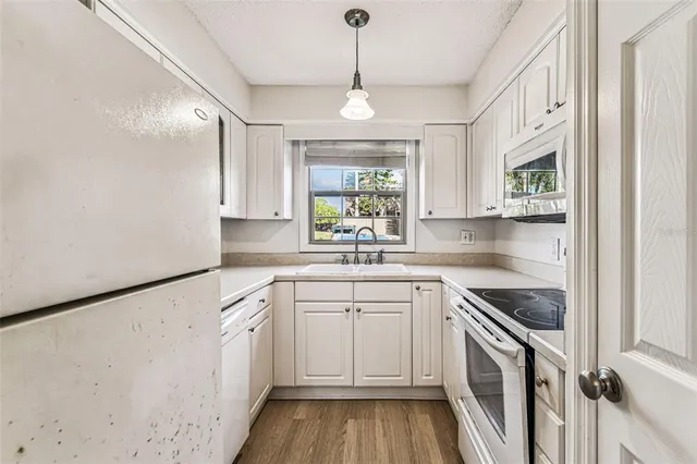 a kitchen with a white cabinets and window