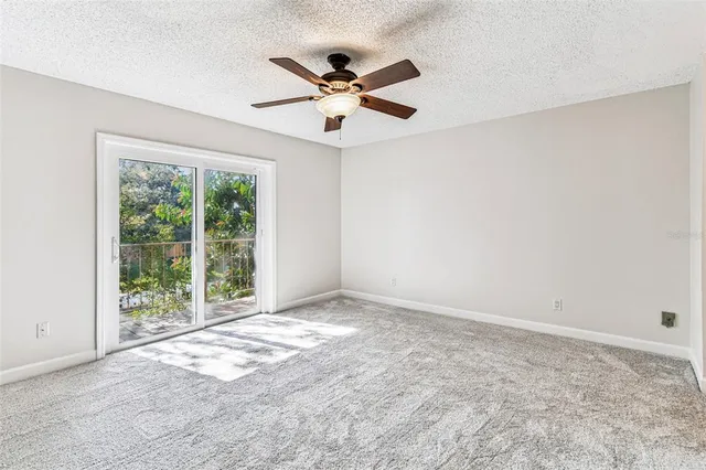 an empty room with window and ceiling fan