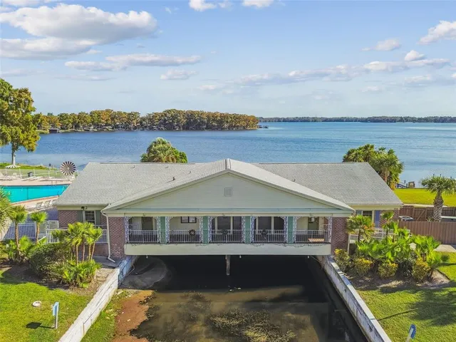 an aerial view of a house with swimming pool and lake view