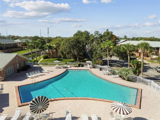 a view of a swimming pool with a patio and a lawn chairs