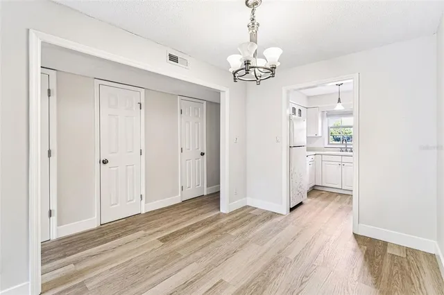 a view of a livingroom with wooden floor closet and windows
