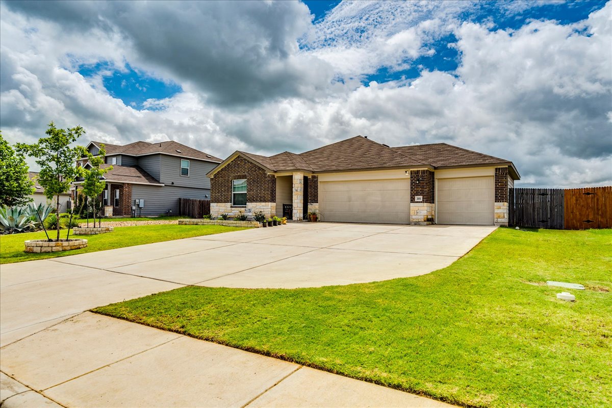389 Salt Springs Road Kyle, TX 78640 - Photo 5 of 30 A well-maintained lawn and extended driveway greet this charming brick and stone home.