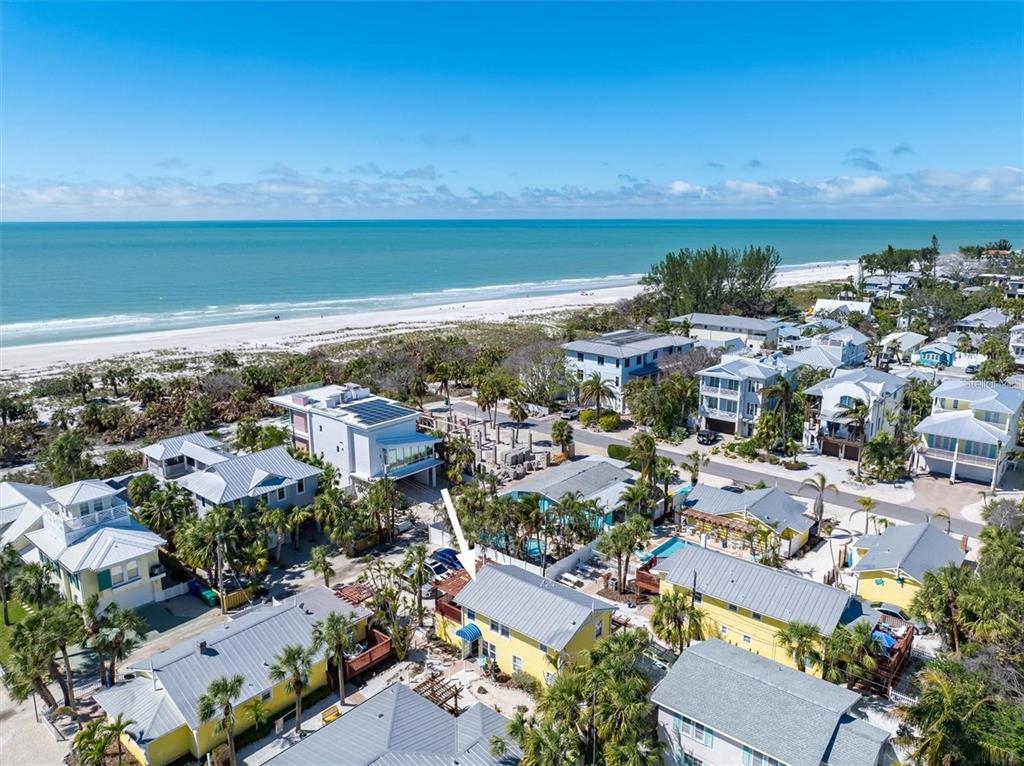 an aerial view of a city with lots of residential buildings and ocean view in back