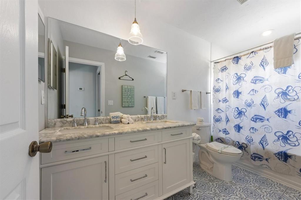 110 Oak Avenue, Unit A Anna Maria, FL 34216 - Photo 15 of 30 a bathroom with a granite countertop sink a toilet and a mirror