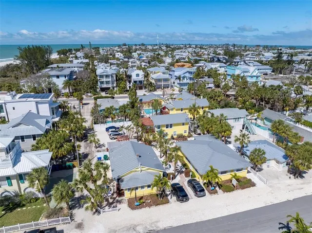 an aerial view of a city with lots of residential buildings ocean and mountain view in back