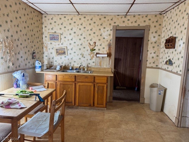 626 High Street Wellsburg, WV 26070 - Photo 7 of 18 Kitchen with wainscoting, wood finish cabinets, light countertops, a drop ceiling, and wallpapered walls
