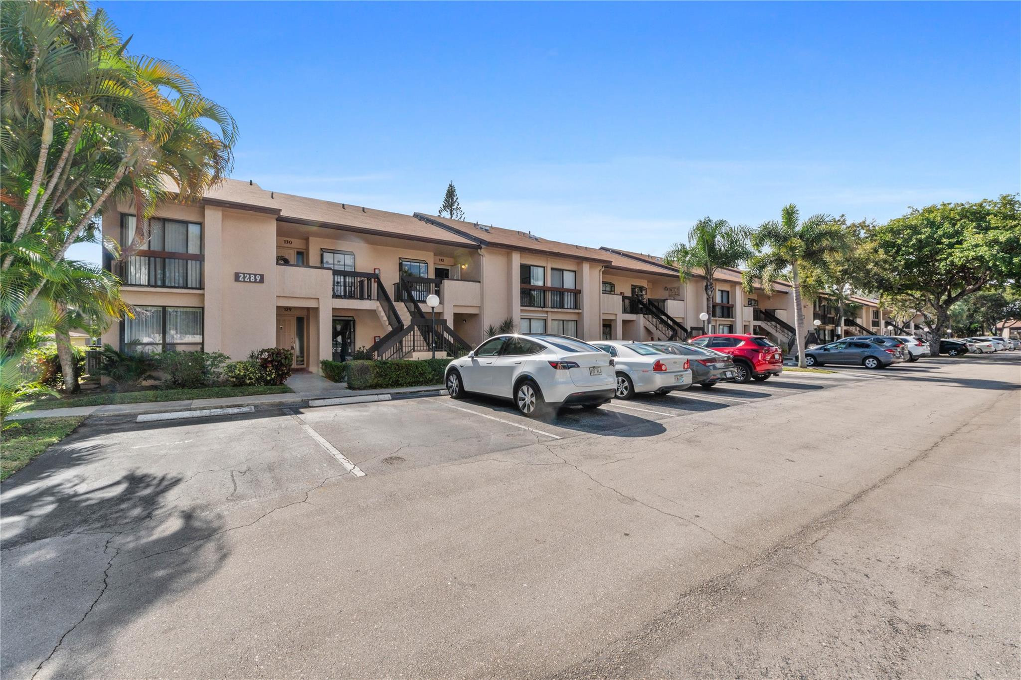 2289 Southwest 15th Street, Unit 129 Deerfield Beach, FL 33442 - Photo 1 of 41 a view of road with card parked on side and retail shops
