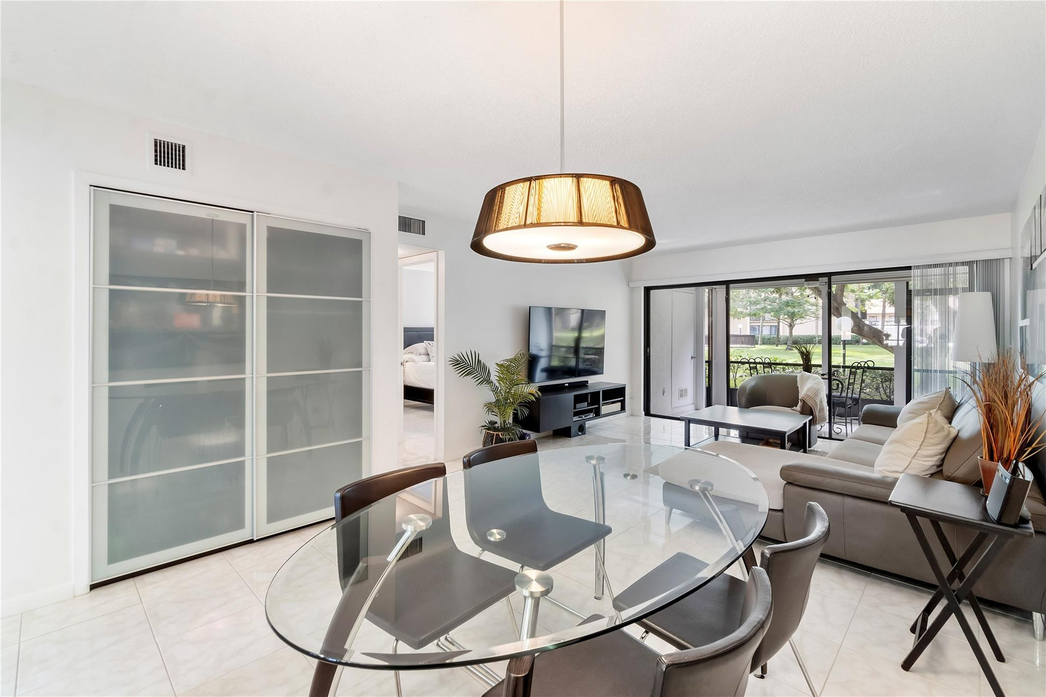 2289 Southwest 15th Street, Unit 129 Deerfield Beach, FL 33442 - Photo 11 of 41 a dining room with furniture a chandelier and wooden floor