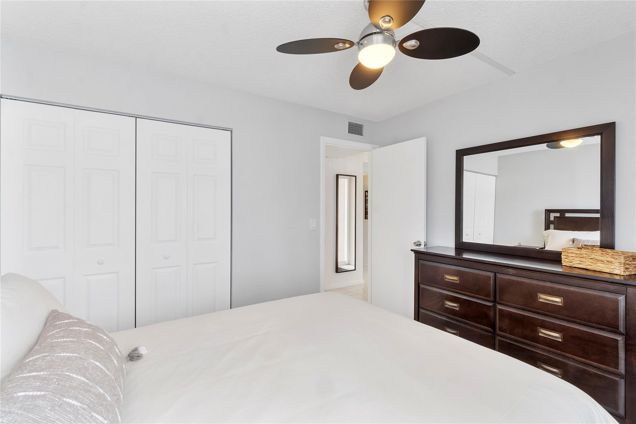 2289 Southwest 15th Street, Unit 129 Deerfield Beach, FL 33442 - Photo 15 of 41 a bedroom with a bed and a chandelier