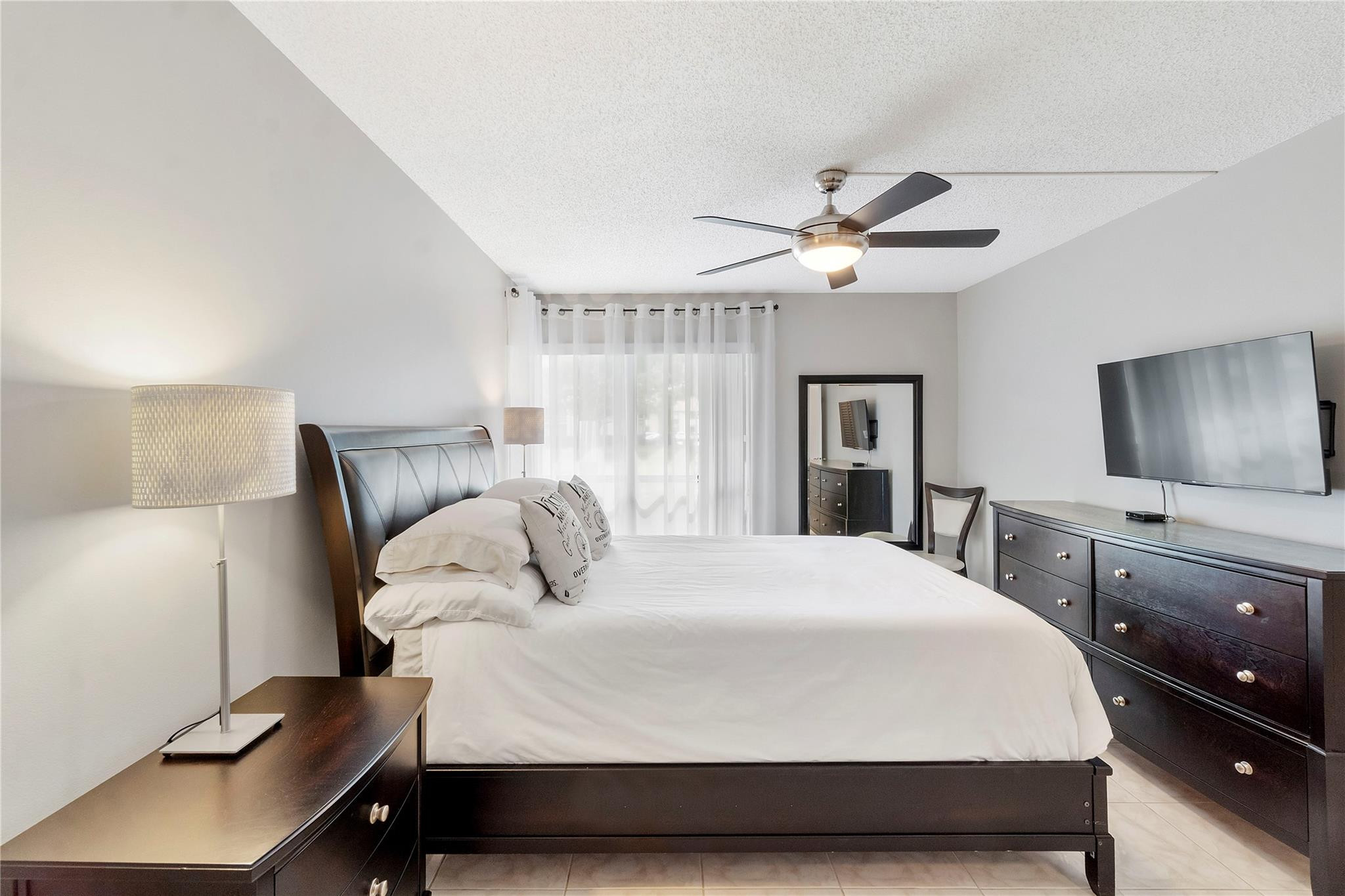 2289 Southwest 15th Street, Unit 129 Deerfield Beach, FL 33442 - Photo 16 of 41 a bedroom with a large bed and a chandelier