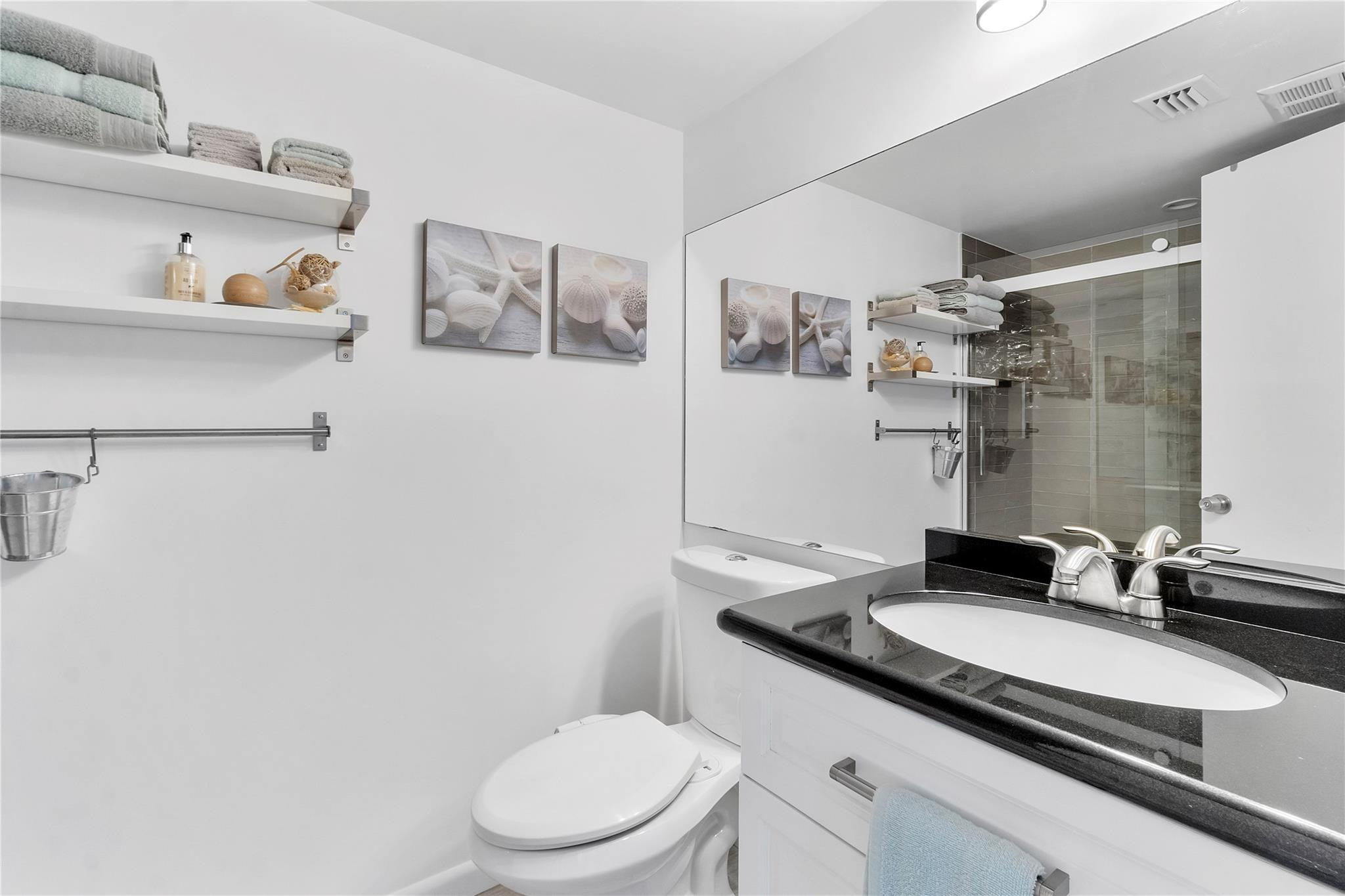 2289 Southwest 15th Street, Unit 129 Deerfield Beach, FL 33442 - Photo 20 of 41 a bathroom with a granite countertop sink a toilet and a mirror