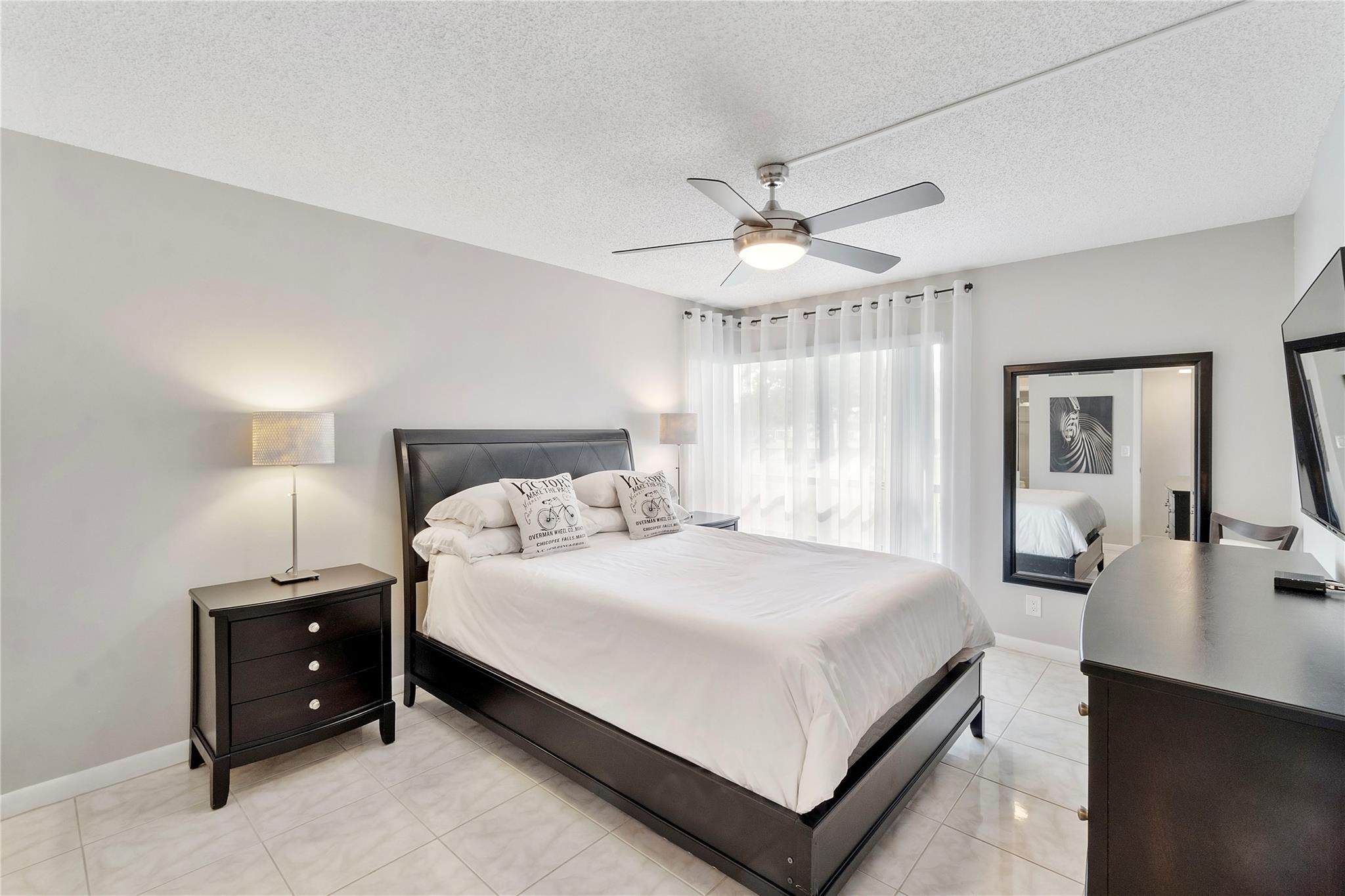 2289 Southwest 15th Street, Unit 129 Deerfield Beach, FL 33442 - Photo 21 of 41 a large bedroom with a bed and a chandelier
