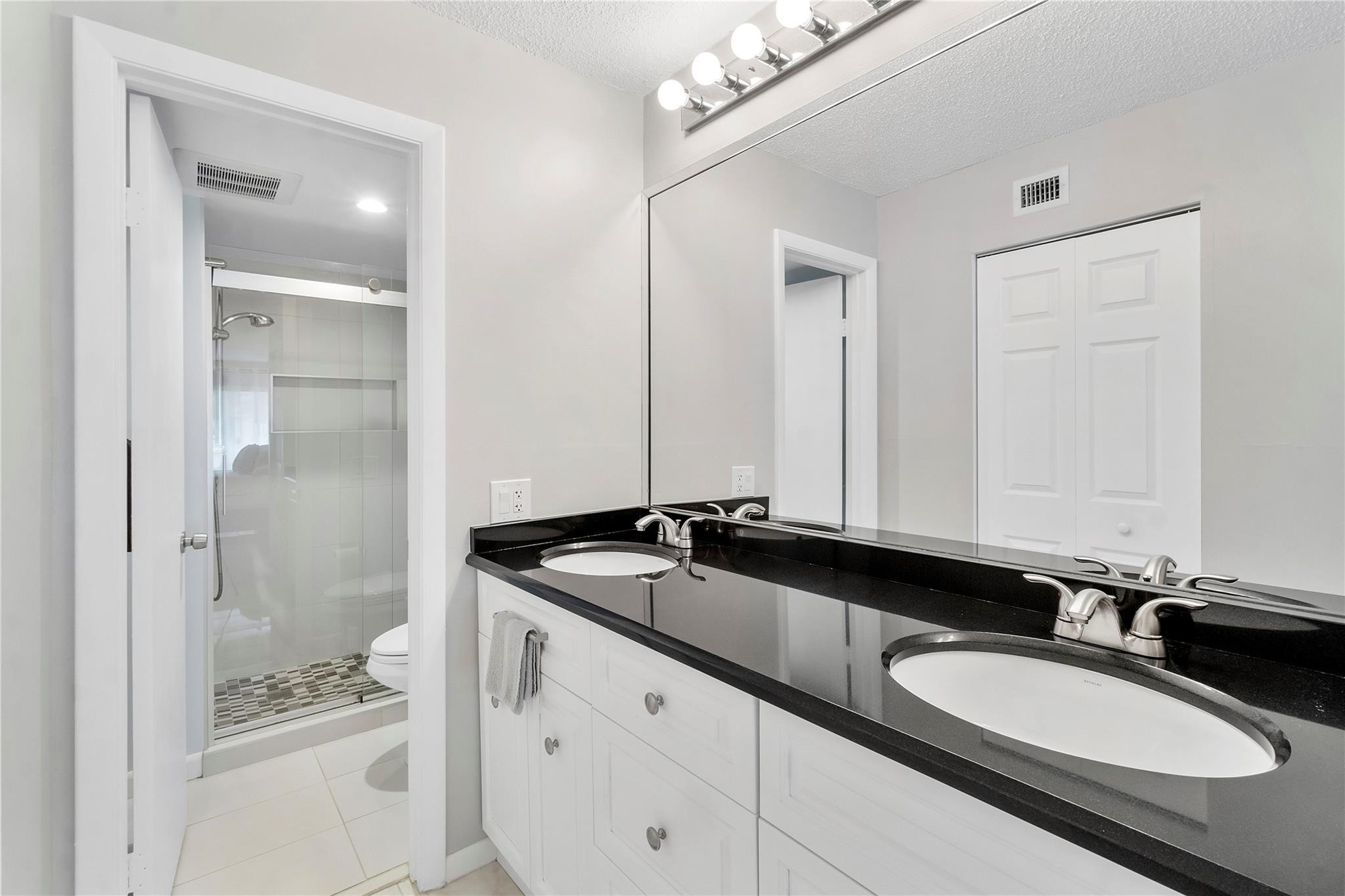 2289 Southwest 15th Street, Unit 129 Deerfield Beach, FL 33442 - Photo 25 of 41 a bathroom with a granite countertop sink and a mirror