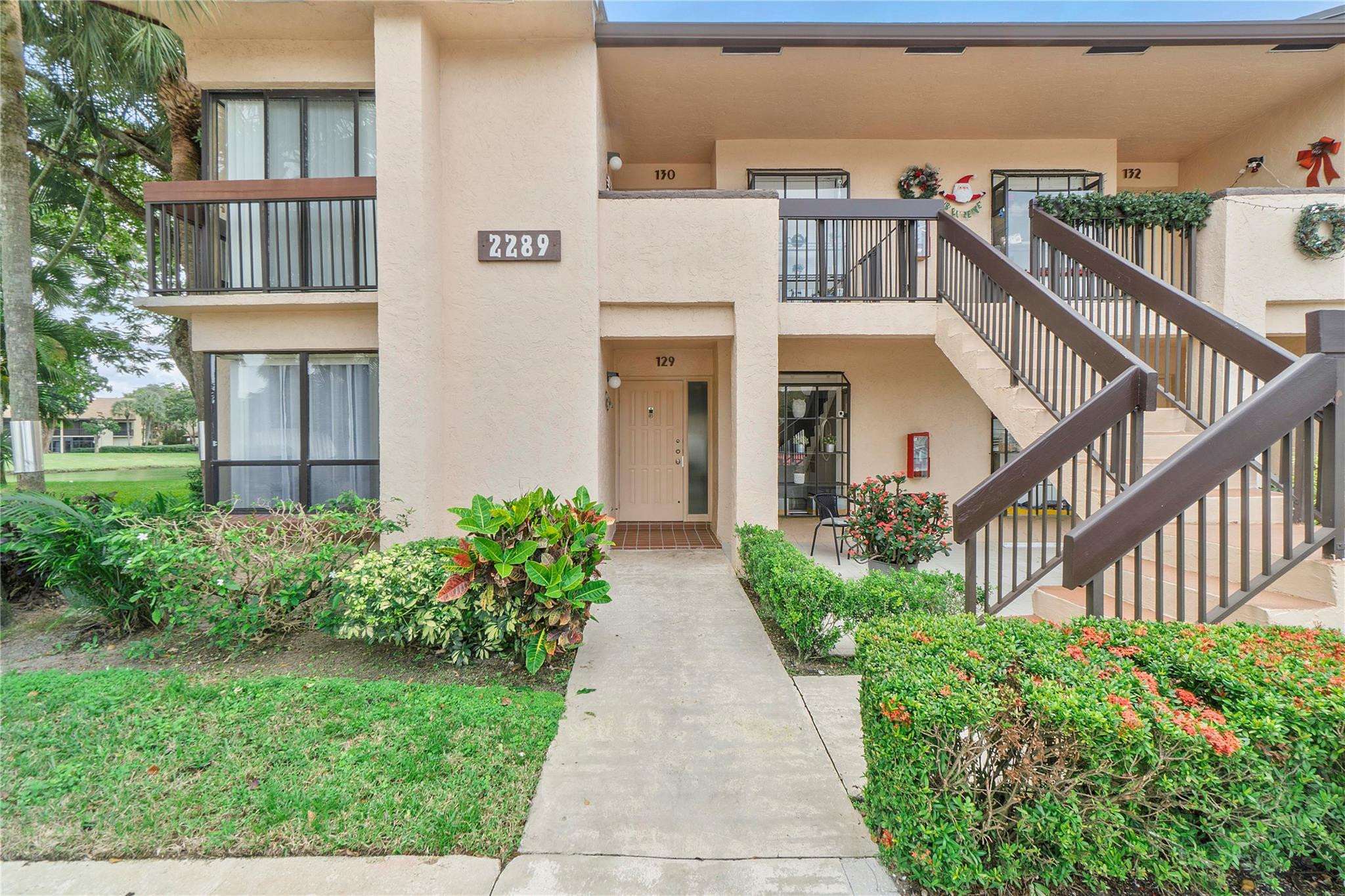 2289 Southwest 15th Street, Unit 129 Deerfield Beach, FL 33442 - Photo 32 of 41 front view of house with a yard and potted plants