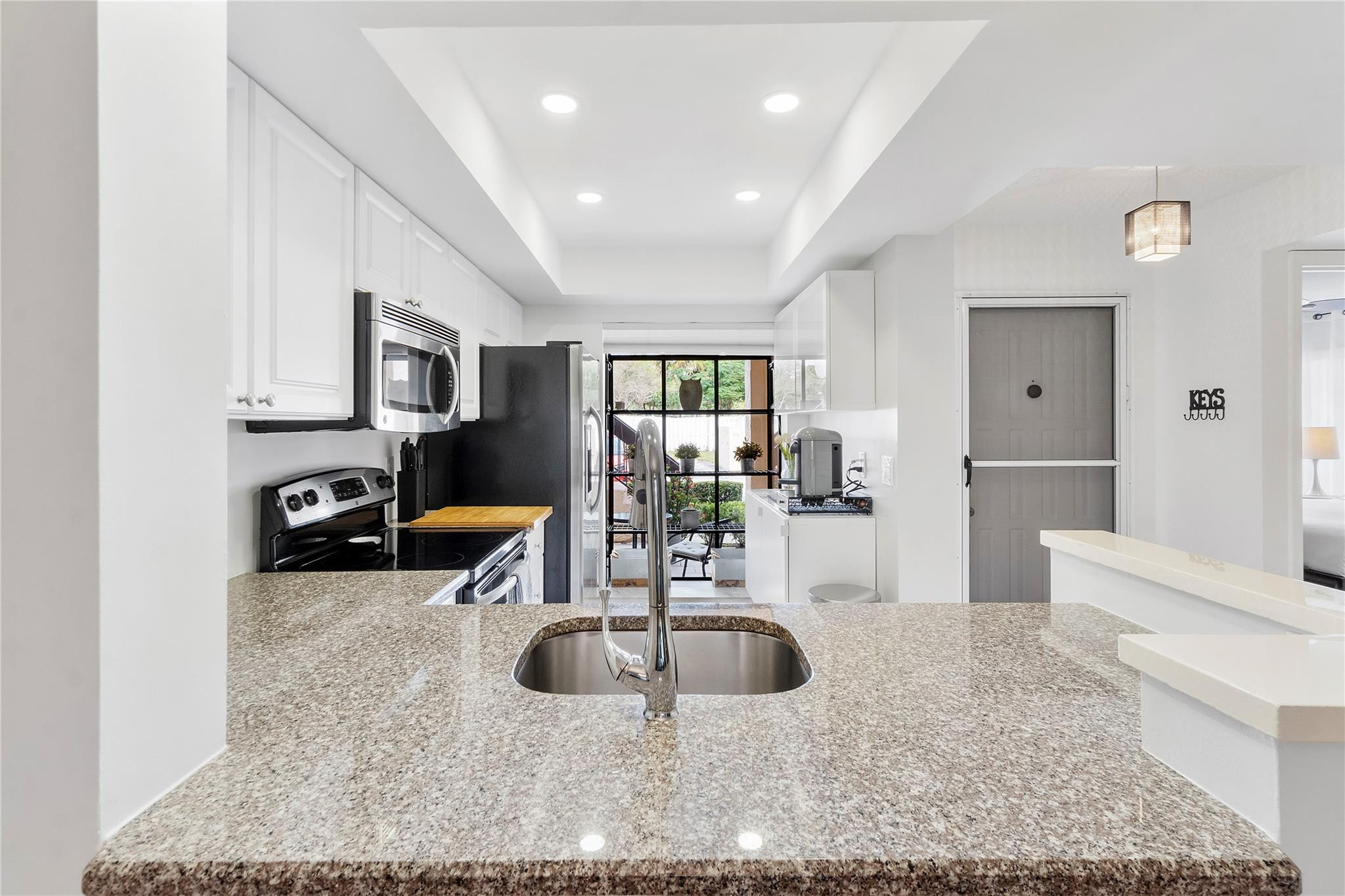 2289 Southwest 15th Street, Unit 129 Deerfield Beach, FL 33442 - Photo 4 of 41 a kitchen with sink a refrigerator and cabinets
