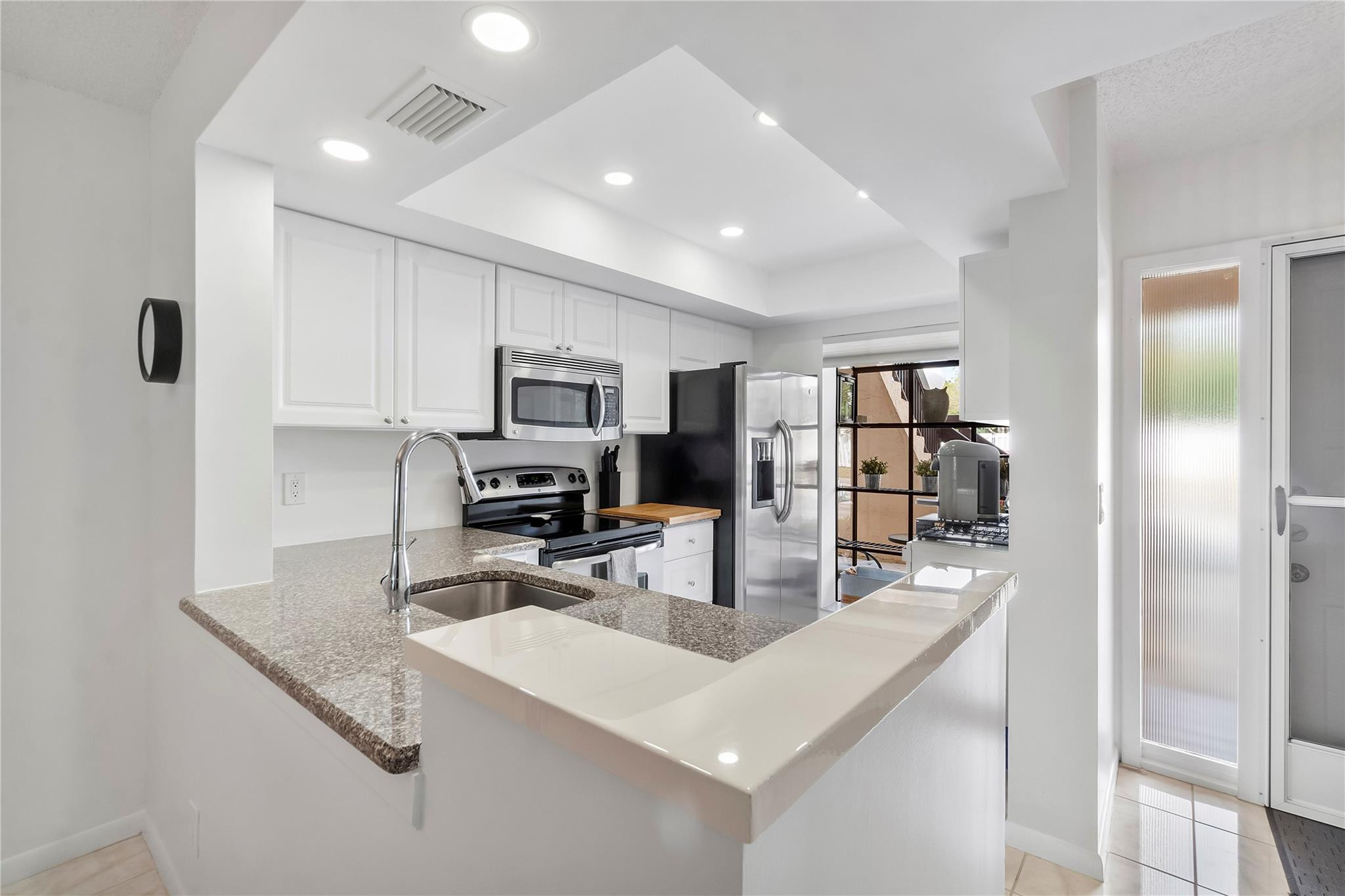 2289 Southwest 15th Street, Unit 129 Deerfield Beach, FL 33442 - Photo 6 of 41 a kitchen with stainless steel appliances granite countertop a sink refrigerator and microwave