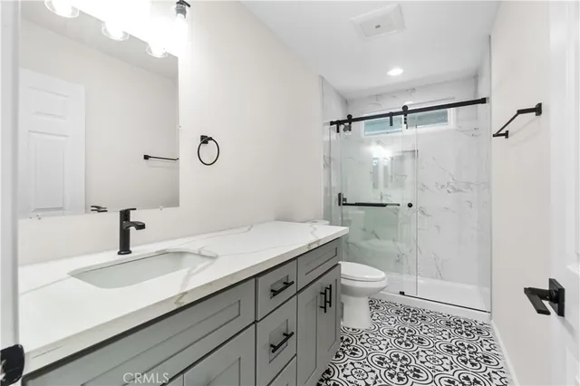 a bathroom with a sink toilet double vanity and shower