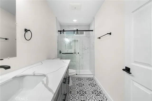 a bathroom with a sink a toilet a shower and a mirror