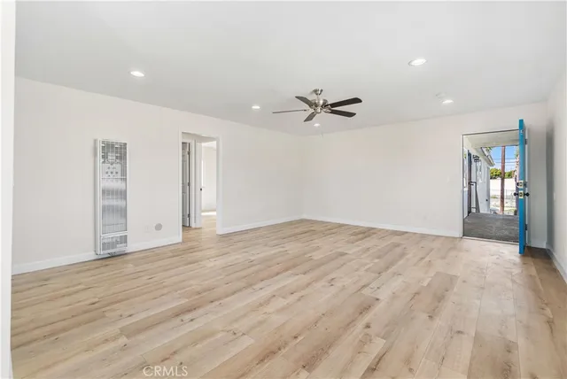 a view of empty room with wooden floor