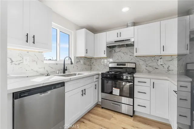 a kitchen with stainless steel appliances granite countertop a sink and cabinets