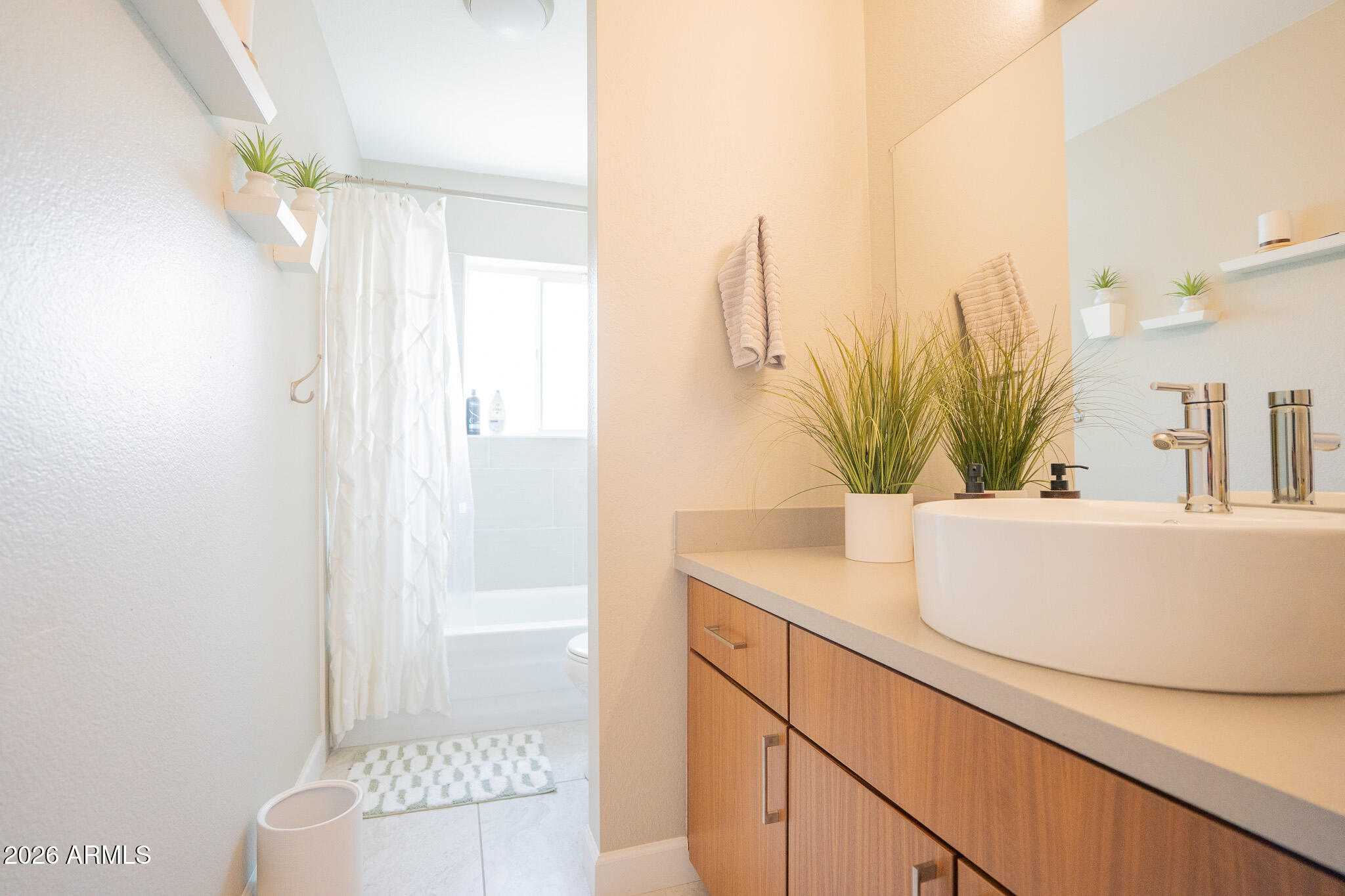 1201 East Rowlands Lane Phoenix, AZ 85022 - Photo 10 of 40 a bathroom with a sink a mirror and a shower