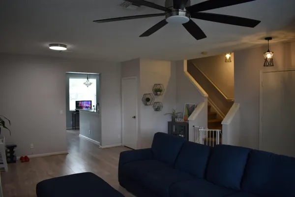a living room with furniture and a wooden floor